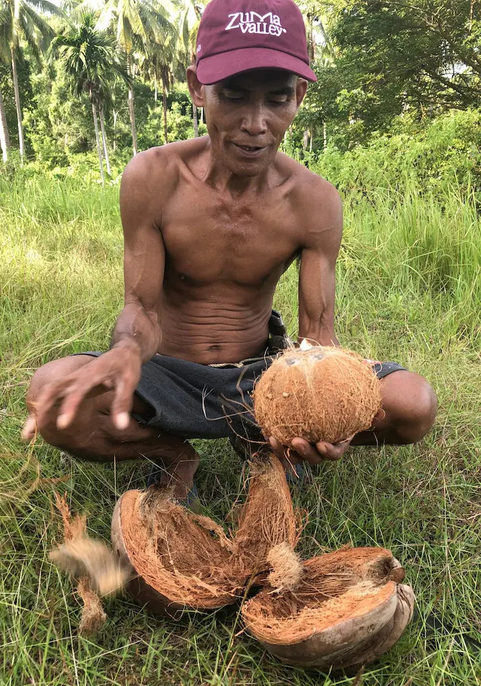 Farmer crouching with coconut